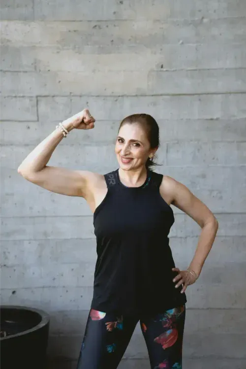 Membre souriante montrant ses biceps.